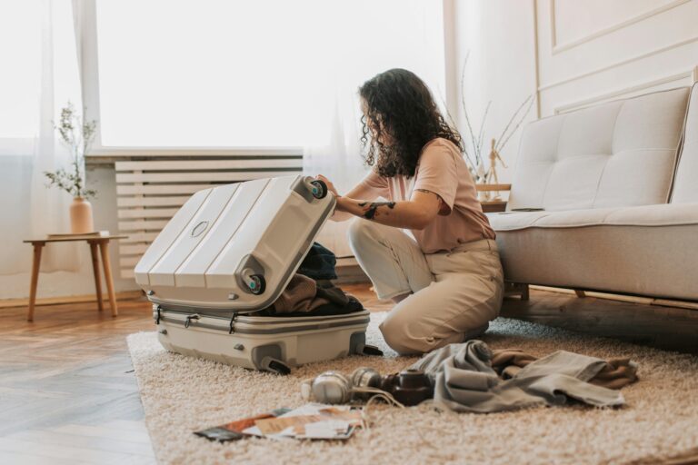 woman packing her carry on luggage in her living room.